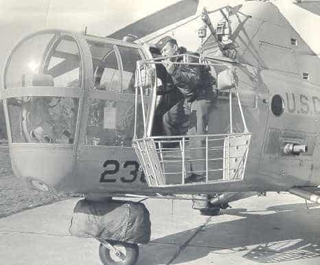 LT Stew Graham at the hatch of a HO3S with a rescue basket attached to the hoist. With the advent of the HO4S the basket could be brought inside the cabin.